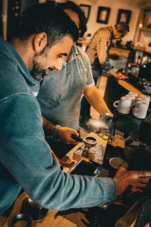 Inhaber in einem Barista Kurs, wie er eine Maschine bedient